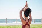 Fitness, black woman and yoga meditation by beach for spiritual wellness or exercise in nature. Sporty female yogi back in warm up arm stretch for zen workout, relax or meditating by ocean coast