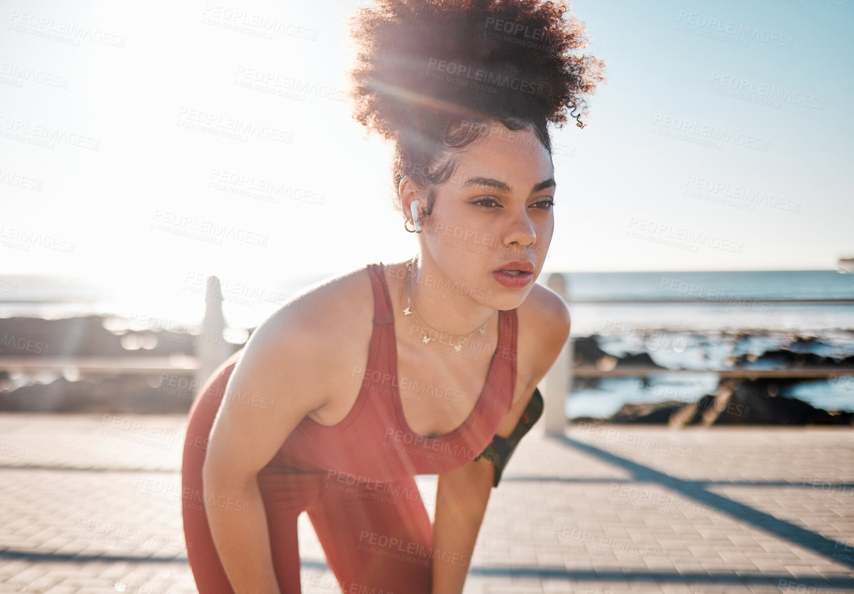 Buy stock photo Exercise, music and tired with a black woman runner on the promenade for cardio or endurance training. Fitness, running and earphones with a sports person feeling exhausted during her workout