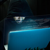 Cyber security, crime and hacker with laptop typing in data center ...