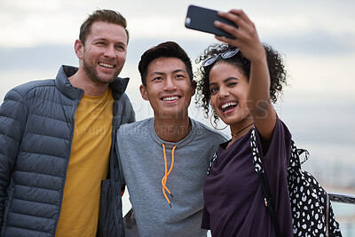 Buy stock photo Men, black woman and friends selfie at beach for holiday travel, together and smile for internet blog post. Outdoor adventure, phone and profile picture for social media app by ocean with diversity