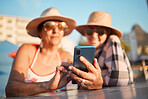 Senior, friends and phone for selfie, internet or search on vacation, break or summer holiday on blue sky background. Elderly, women and profile picture photo at an outdoor restaurant while traveling