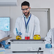 Science, laboratory and team with chemistry liquid in glass beaker for ...