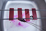 Red, blood and glass slide in laboratory stain research, dna cell engineering or acid particles chemistry in top view sink. Zoom, science and healthcare dye study in medical pharmacy with cotton swab