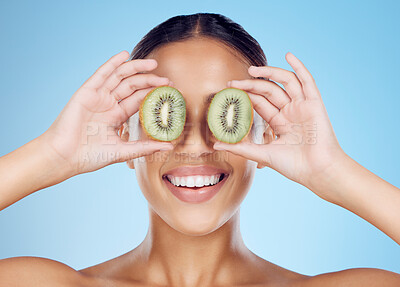 Buy stock photo Kiwi, woman and beauty for healthy cosmetics, natural skincare product and blue studio background. Happy model, organic fruit and vitamin c nutrition for vegan diet, detox wellness and face aesthetic