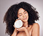 Coconut, beauty and black woman isolated on studio background for natural skincare, face and hair dream. USA model or young person sleeping with fruit product and healthy oil benefits for dermatology