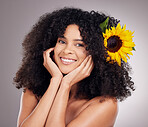 Portrait, sunflower and black woman with skincare, cosmetics and dermatology on grey studio background. Face detox, African American female and lady with plants, happiness and makeup for smooth skin