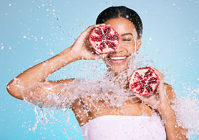 Buy stock photo Beauty, skin care and woman with a pomegranate for healthy skin and diet on a blue background. Face of aesthetic model person with water splash and fruit for sustainable facial health and wellness