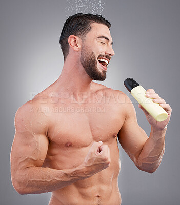 Buy stock photo Water, shower and man singing with shampoo bottle in hand, skincare and cleaning hair and body in studio. Karaoke, bathroom routine and muscular model with smile and music isolated on grey background