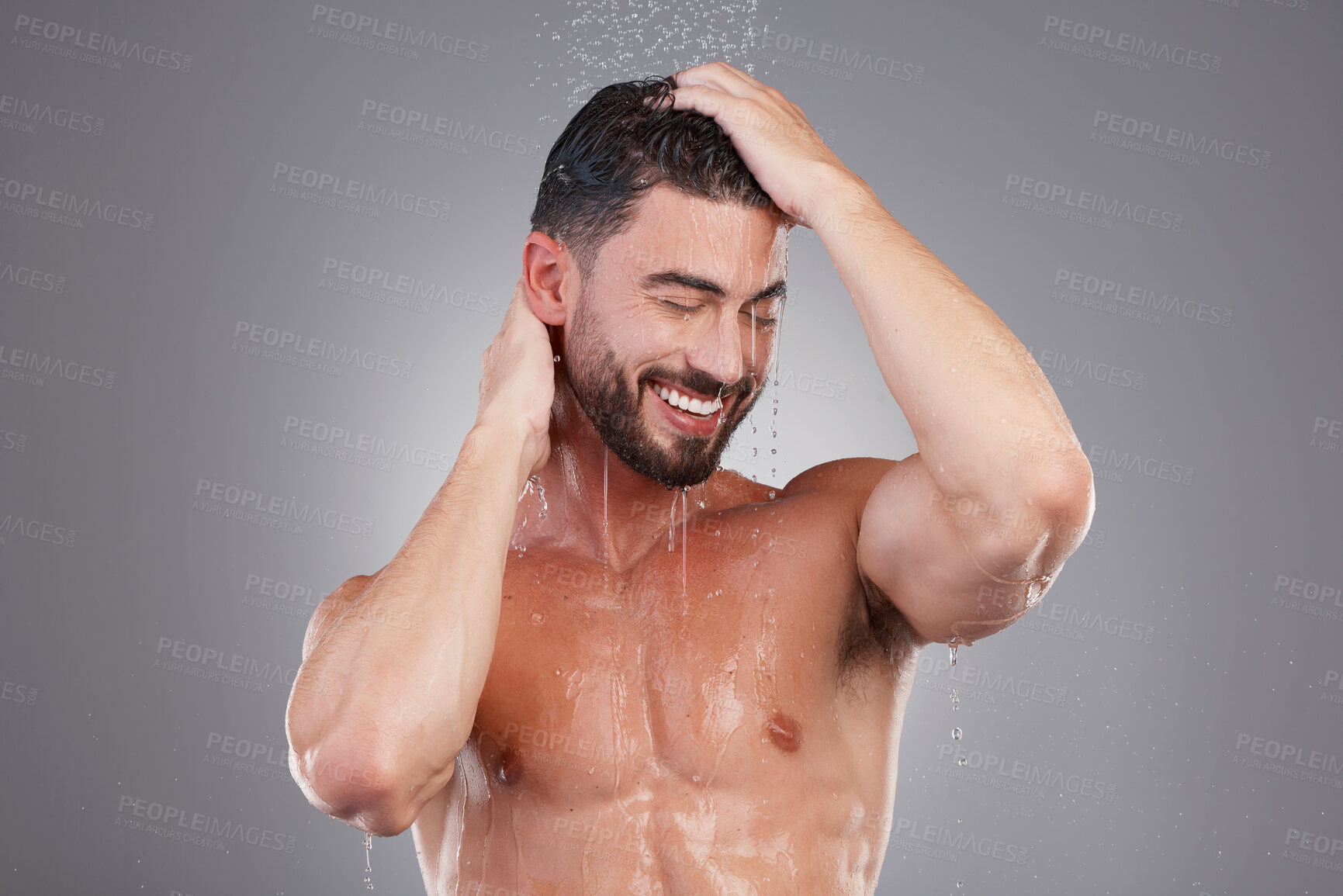 Buy stock photo Shower, keratin and cleaning hair with a man in studio on a gray background for hygiene or grooming. Water, haircare and washing with a handsome young male in the bathroom for shampoo treatment