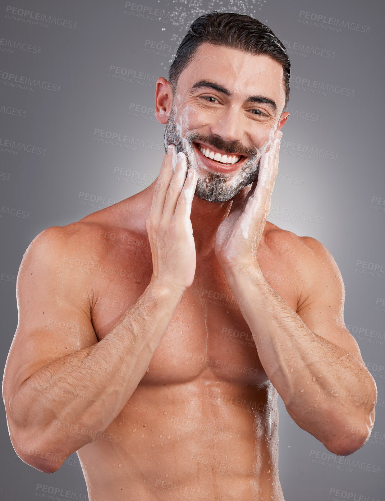 Buy stock photo Soap, beard and portrait of a man in the shower isolated on a grey studio background. Skincare, cleaning and model washing facial hair for grooming, hygiene and morning routine on a backdrop