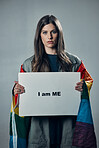 Woman, protest and poster in pride for gay, LGBTQ equality or human rights against gray studio background. Portrait of confident female activist with I am me message board for sexuality empowerment