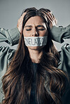 Woman, tape and mouth with quiet protest, social activism and global economy crisis by background. Inflation, gen z girl and studio backdrop with economic opinion, stress and financial freedom vision