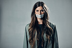 Woman, protest and tape on mouth for inflation, economic change or financial crisis against gray studio background. Portrait of female activist with message to end government greed or taxes on mockup