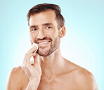 Skincare, cotton pad and portrait of a man in studio for health, grooming and hygiene routine. Beauty, wellness and handsome male model doing fresh morning face treatment isolated by blue background.