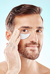 Face, skincare and man with eye patch in studio isolated on a blue background. Beauty, portrait and male model with  pad product for dermatology, cosmetics and facial treatment, wellness and health.