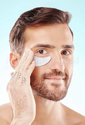 Buy stock photo Face, skincare and man with eye patch in studio isolated on a blue background. Beauty, portrait and male model with  pad product for dermatology, cosmetics and facial treatment, wellness and health.