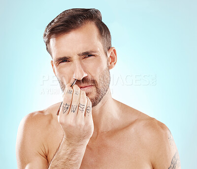 Buy stock photo Man with tweezer, grooming nose hair and morning routine for beauty and skincare isolated on blue background. Face, aesthetic and pain, plucking facial hairs, male model with tattoo on hand in studio