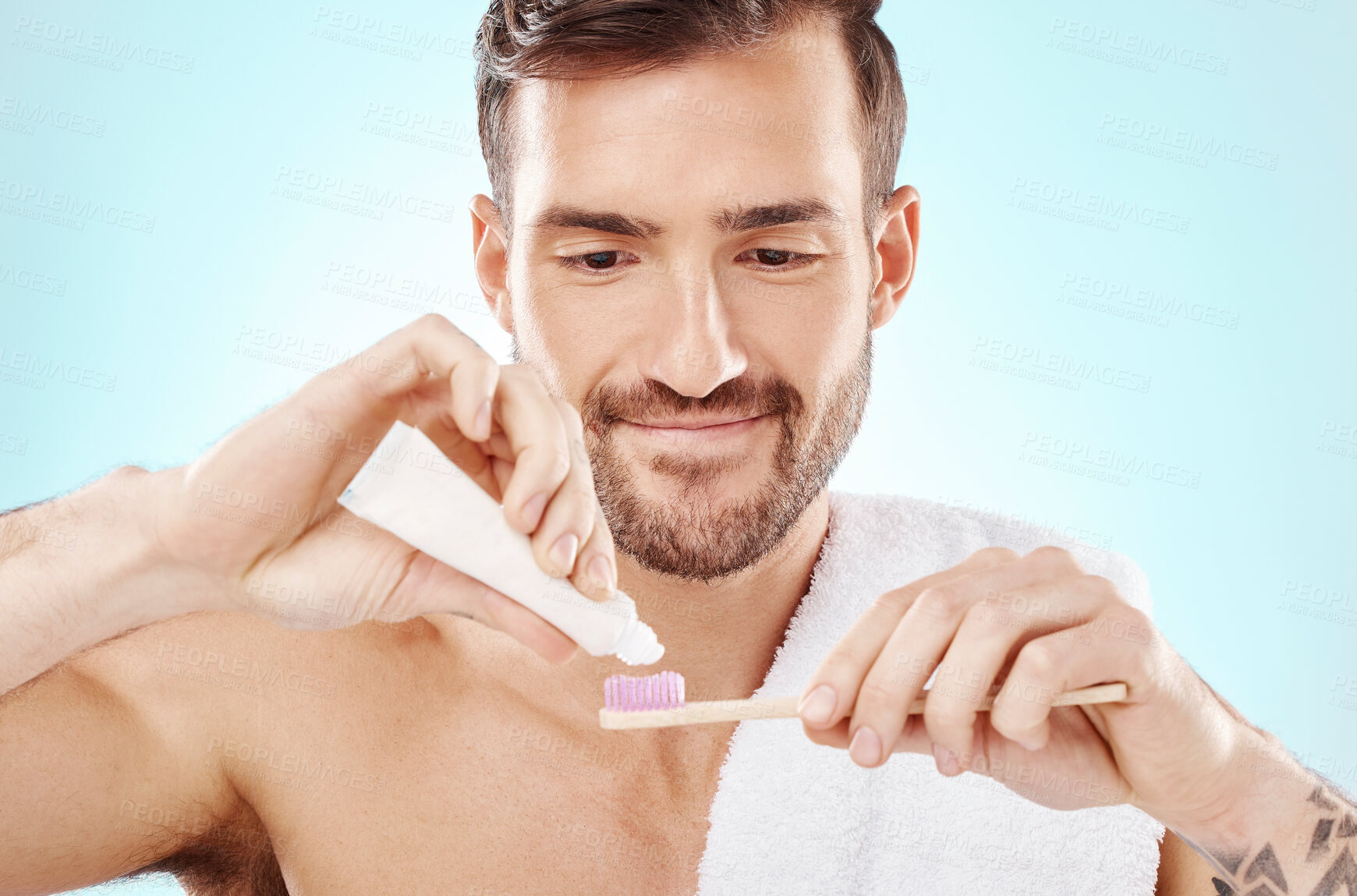 Buy stock photo Bamboo toothbrush and toothpaste of man isolated on a blue background for dental orthodontics health. Beauty model or happy person brushing teeth with eco friendly and sustainable product in studio