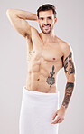 Clean, body and portrait of a man from the shower isolated on a grey studio background. Hygiene, grooming and happy shirtless model with a towel after a wash for a morning routine on a backdrop