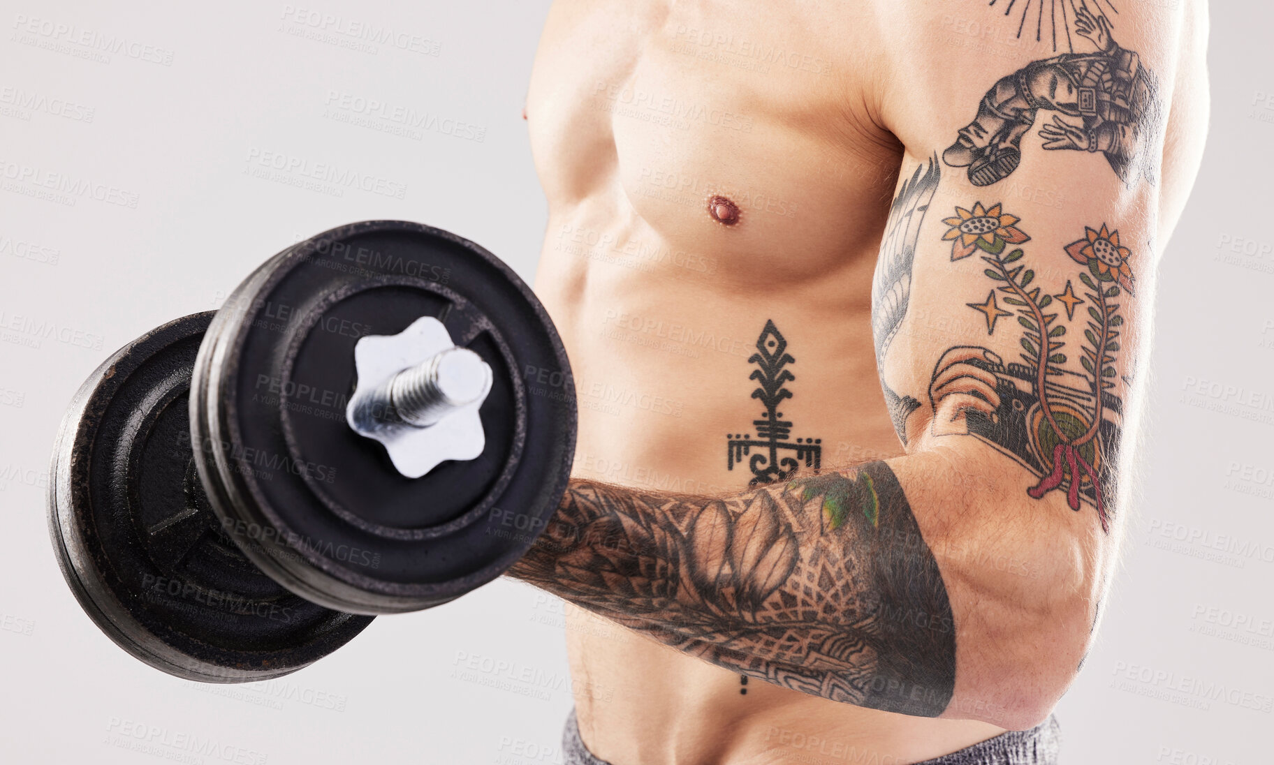 Buy stock photo Arm muscle, dumbbell and man with tattoo and workout in a studio for fitness, exercise and power. Gray background, isolated and gym model weightlifting, bodybuilding and doing body wellness training