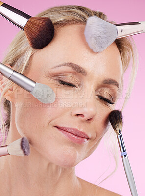 Buy stock photo Makeup, glam and face of a woman with brushes isolated on a pink background in a studio. Beauty, foundation and mature model with cosmetics from a beautician for a glamour look on a backdrop