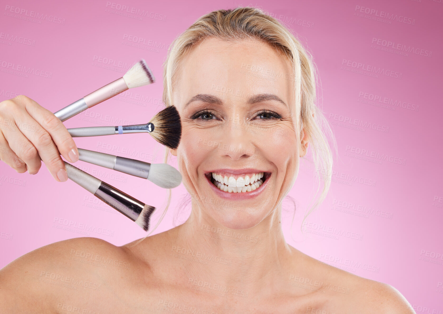 Buy stock photo Portrait, makeup and cosmetic brushes with a mature woman in studio on a pink background to promote a product. Face, happy and cosmetics with an attractive older female posing for beauty treatment