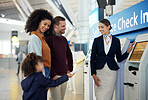 Woman, services agent and family at airport by self service check in station for information, help or FAQ. Happy female passenger assistant helping travelers register or book airline flight ticket