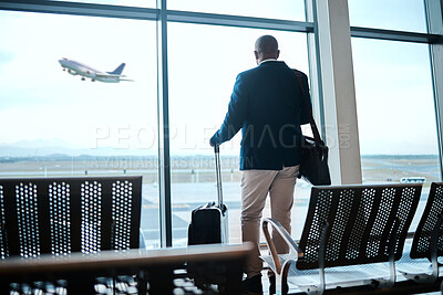 Buy stock photo Airport, suitcase and businessman waiting to board flight by the terminal for corporate work trip. Travel, luggage and professional male traveler watching flying plane by a window in terminus lounge.