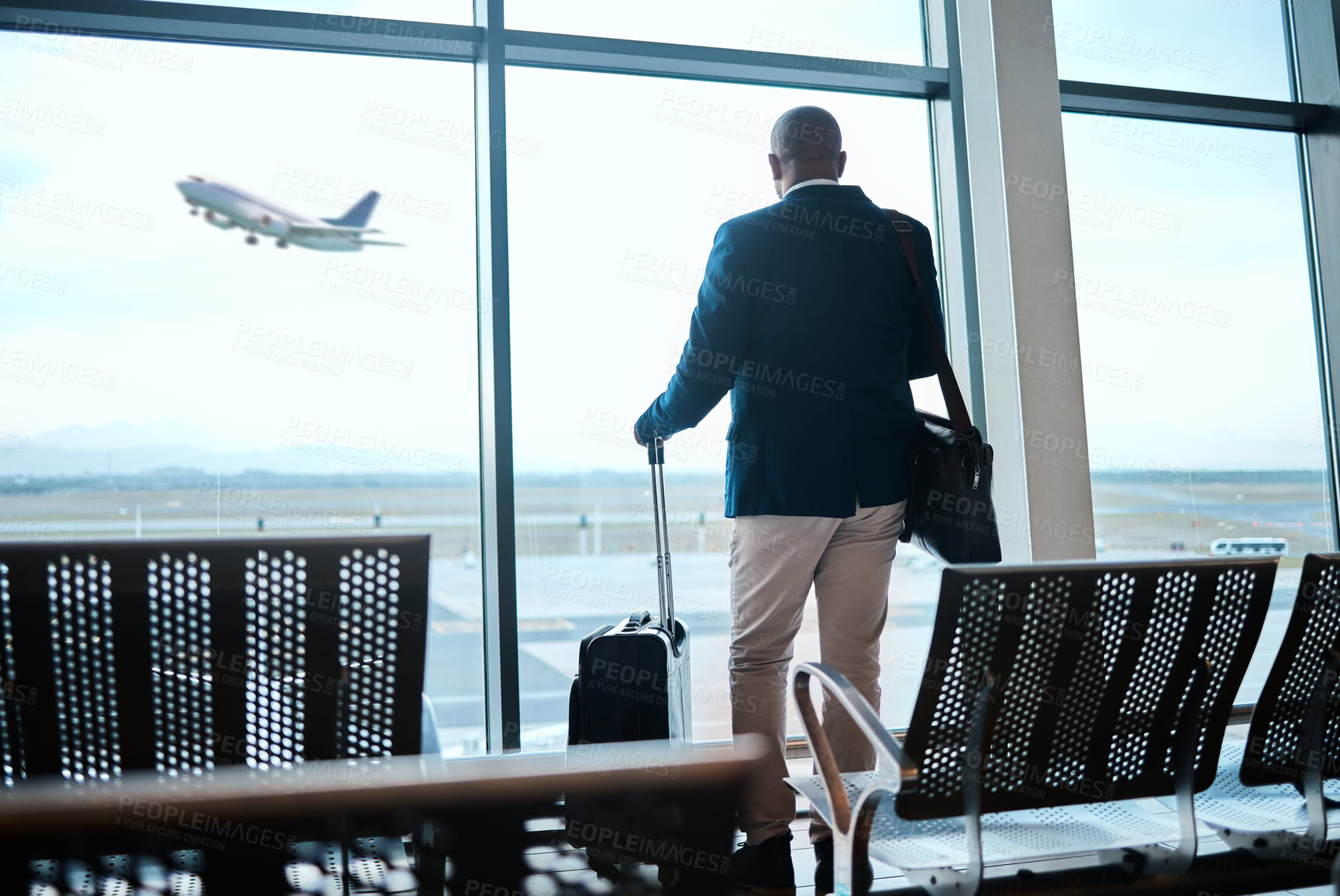 Buy stock photo Airport, suitcase and businessman waiting to board flight by the terminal for corporate work trip. Travel, luggage and professional male traveler watching flying plane by a window in terminus lounge.