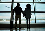 Silhouette, travel and holding hands with couple in airport for departure, flight and vacation break. Shadow, holiday and tourism with man and woman by window for journey, international and boarding