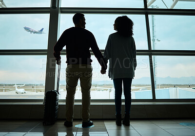 Buy stock photo Silhouette, travel and holding hands with couple in airport for departure, flight and vacation break. Shadow, holiday and tourism with man and woman by window for journey, international and boarding