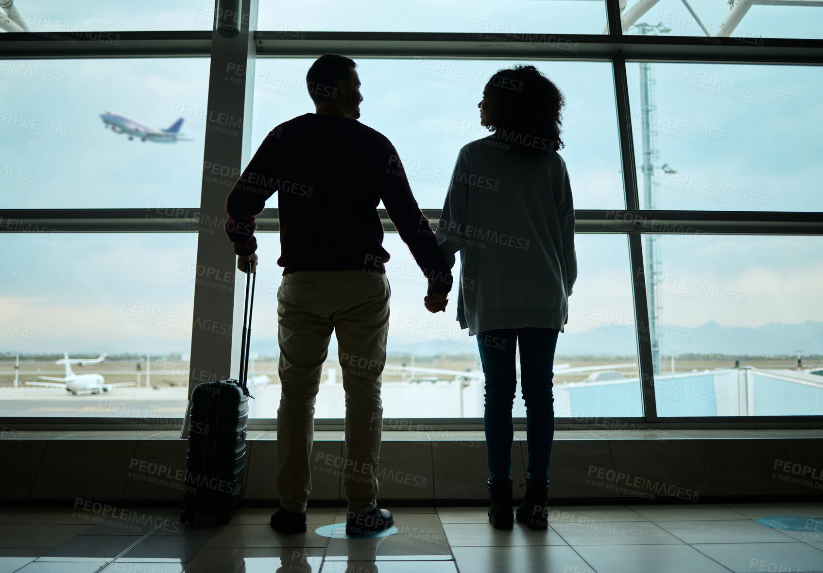 Buy stock photo Silhouette, travel and holding hands with couple in airport for departure, flight and vacation break. Shadow, holiday and tourism with man and woman by window for journey, international and boarding