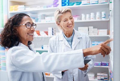 Buy stock photo Pharmacy women, shelf and pointing together with smile, stock and product for medical wellness in store. Pharmacist training, management and teamwork for medicine, service and healthcare in shop