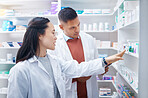 Pharmacist, coworkers and conversation with pills, medicine and inventory for stock with discussion. Pharmacy, man or Asian woman with healthcare,  prescriptions or coaching for new process or system