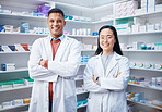 Portrait, teamwork and pharmacists with arms crossed in pharmacy, drugstore and medicine shop. Healthcare, pharma wellness and happy, proud and confident smile of medical doctors, man and Asian woman