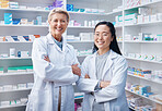 Portrait, women teamwork and pharmacists with arms crossed in pharmacy, drugstore or shop. Healthcare, medication store and happy, proud or confident medical doctors, senior woman and Asian female.