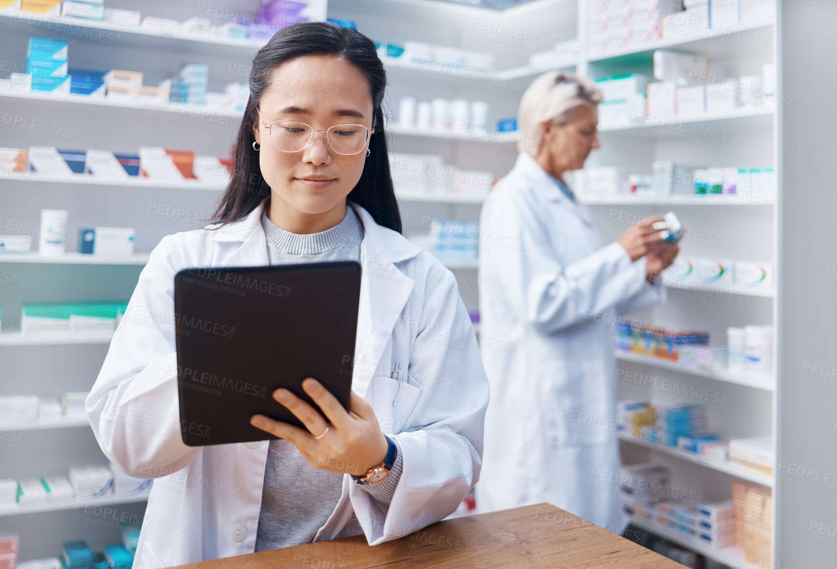 Buy stock photo Asian woman, tablet and pharmacist in pharmacy for healthcare or online consultation in drugstore. Medication, telehealth technology and female medical doctor with touchscreen for research in shop.