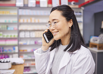 Buy stock photo Pharmacy, phone and healthcare worker talking with a mobile connection at work. Asian woman, pharmacist and business communication of a dispensary employee with a smile from conversation in store