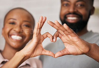 Love, hands in heart and black couple with smile for relationship, dating and commitment in home. Happy, emoji and face of black woman and man smile with hand shape for bonding, romance and trust