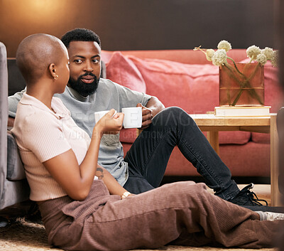 Buy stock photo Coffee, love and valentines day with a black couple sitting on the living room floor together for romance. Relax, date or romantic with a man and woman spending time in their home for bonding
