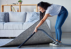 Woman, vacuum and cleaning carpet floor in housekeeping for clean sanitary hygiene at home. Happy female cleaner in germ or dust removal in living room interior by sofa for daily chores or routine