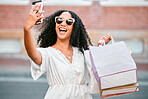 Fashion, shopping bags and woman taking a selfie in the city standing in the street. Black woman with gifts, 5g phone in hand and taking a picture in retail shopping mall, happy from sale or discount