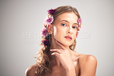Buy stock photo Portrait, skincare and woman with flowers, cosmetics and dermatology with lady on grey studio background. Face, female and lady with plants, florals in hair or makeup with grooming or morning routine