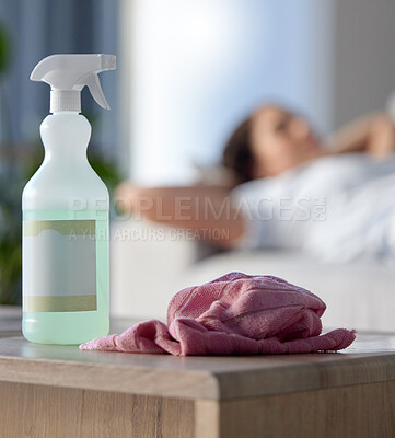 Buy stock photo Cleaning, covid or hygiene with supplies in a house with a woman cleaner taking a break in the background. Home, product and housekeeping with a spray, disinfectant or sanitizer for health and safety