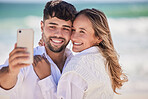 Beach, love and happy couple taking a selfie while on a date for valentines day, romance or anniversary. Happiness, smile and young man and woman hugging while taking picture by the ocean on vacation