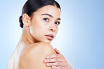 Portrait, aesthetic and mockup with a model black woman in studio on a blue background for skincare. Face, beauty and spa with an attractive young female posing next to blank or empty mock up space