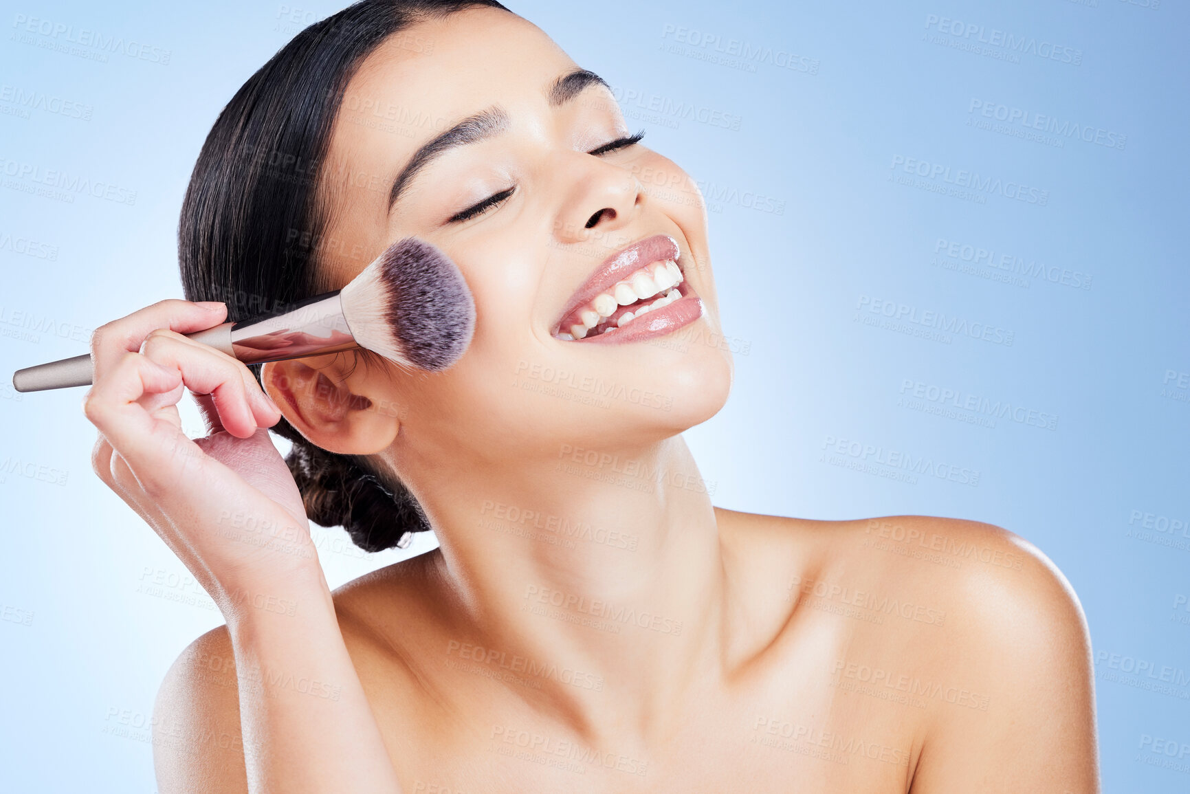 Buy stock photo Makeup, happy and woman with beauty brush on blue background for cosmetics, powder and foundation. Skincare, spa aesthetic and girl face with cosmetology tool for facial product, treatment and salon