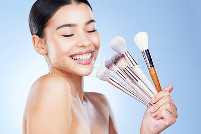 Buy stock photo Makeup, beauty brushes and woman with smile on blue background for cosmetics, powder and foundation. Skincare, cosmetology and face of girl with brush in hands for application, salon and wellness