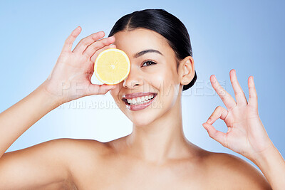 Buy stock photo Lemon, beauty and woman with perfect sign or gesture with hand covering eye with fruit isolated in studio blue background. Cosmetics, skincare and portrait of self care model, citrus and Vitamin C