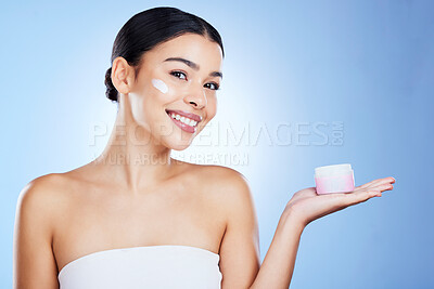 Buy stock photo Woman, face and smile for skincare moisturizer, cosmetics or beauty against a blue studio background. Portrait of happy female smiling with product, lotion or cream for facial treatment on mockup